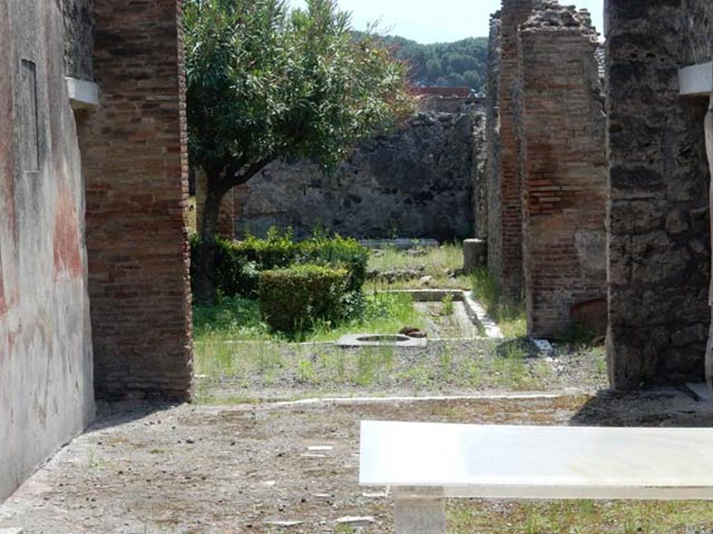 I.8.5 Pompeii.  May 2015. Looking south across tablinum towards garden area.  
Photo courtesy of Buzz Ferebee. Seen on the left, the east wall of the tablinum had a black zoccolo (lower portion) with painted plants with edges formed from a single line and separated by narrow geometrical compartments. The middle zone of the wall had a black central panel with a painting (now removed); the side panels were red with vignettes of painted panthers, and there was a cornice of moulded stucco; the upper zone of the wall was ruined and rough.

