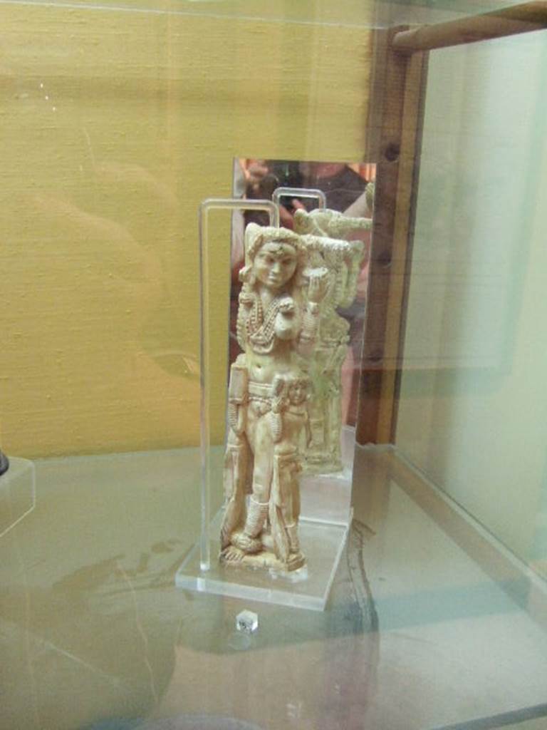 I.8.5 Pompeii. Ivory statuette of Lakshmi.  Found in a wooden chest on the west side of the Viridarium 8.  Now in Naples Archaeological Museum. Inventory number 149425. According to Jashemski, Della Corte stated that the small Indian statuette was found October 24th 1938 in the nearby I.8.19. He thought it had been thrown down, when the south-west corner of the peristyle of this house had collapsed. Maiuri said that the statuette had been stored in a wooden chest in one of the rustic rooms off the portico, together with various objects of domestic use.
Maiuri “Statuette eburnean d’arte Indiana a Pompeii, Le arti (1938) pp 111-115.  Della Corte, M., 1965.  Case ed Abitanti di Pompei. Napoli: Fausto Fiorentino.(p.333-4).  See Jashemski, W. F., 1993. The Gardens of Pompeii, Volume II: Appendices. New York: Caratzas. (p.42)
According to Berry, the statuette was found in the House of the Four Styles (I.8.17).  See Berry, J., 2007. The Complete Pompeii. London, Thames & Hudson, (p.200)

