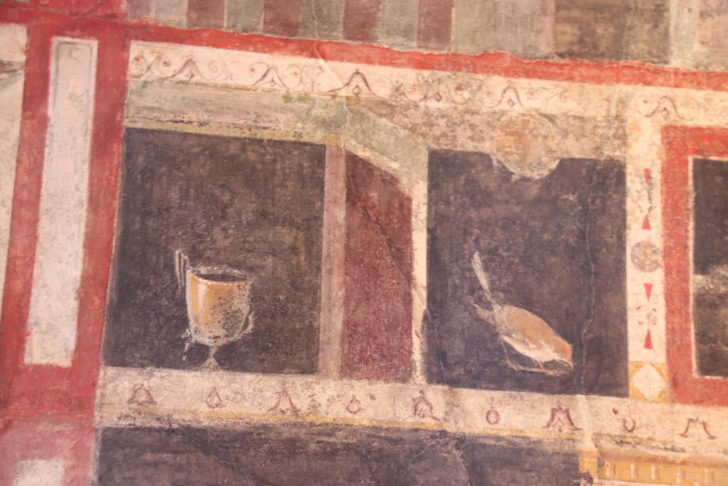 I.9.5 Pompeii. October 2023. Room 10, triclinium, detail from south side of upper centre of east wall. Photo courtesy of Klaus Heese.