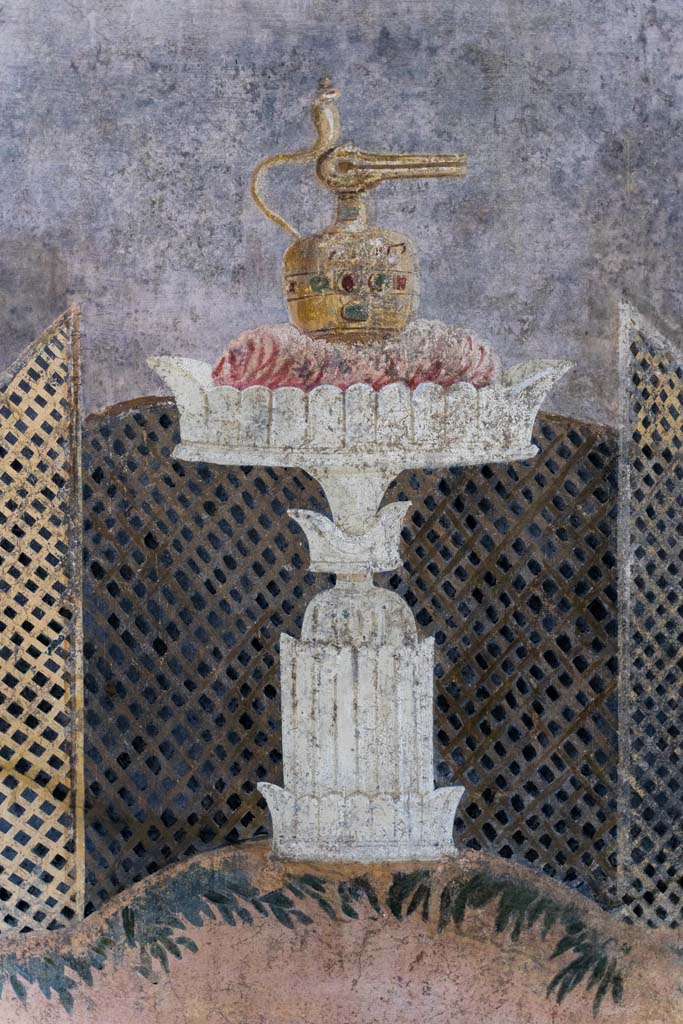 I.9.5 Pompeii. April 2022. Room 11, detail of painted table with Isis jug or jar on east wall. Photo courtesy of Johannes Eber.
