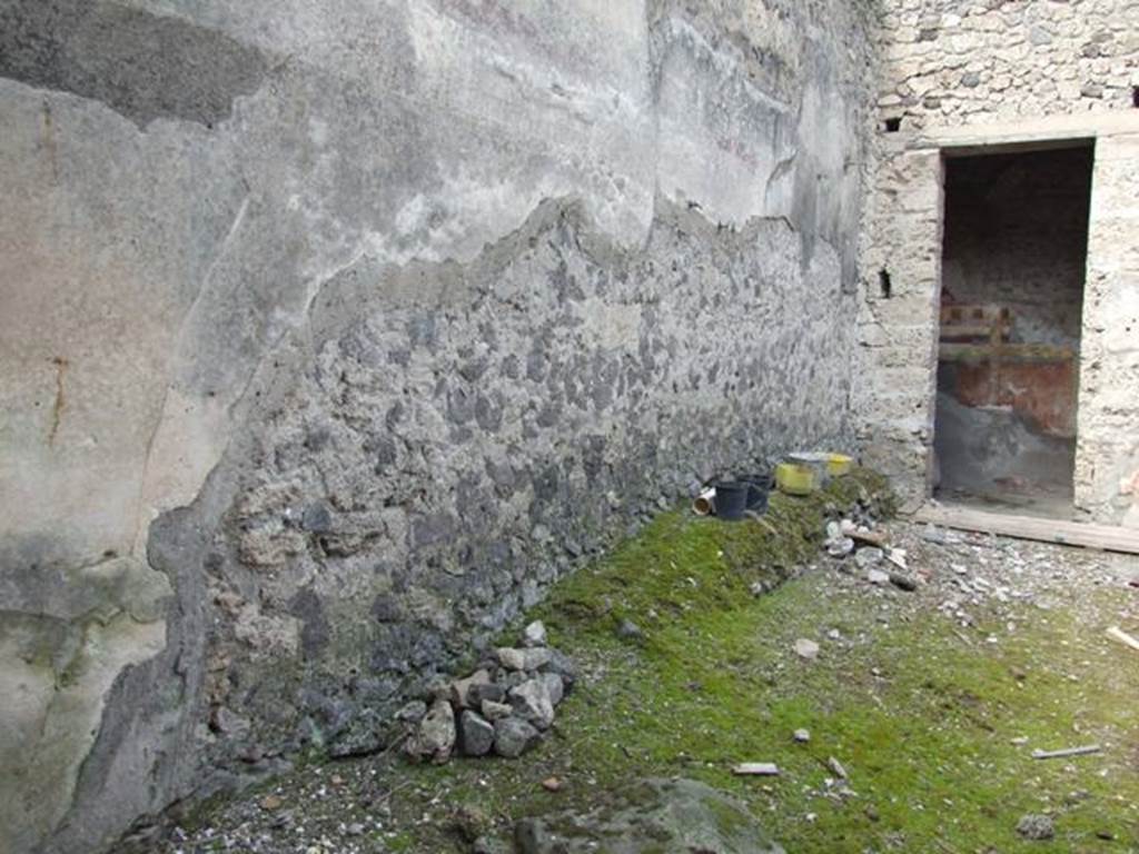 I.9.14 Pompeii. March 2009. Room 8, north-west corner of atrium. Long masonry structure built against the west wall, and doorway to room 9.
