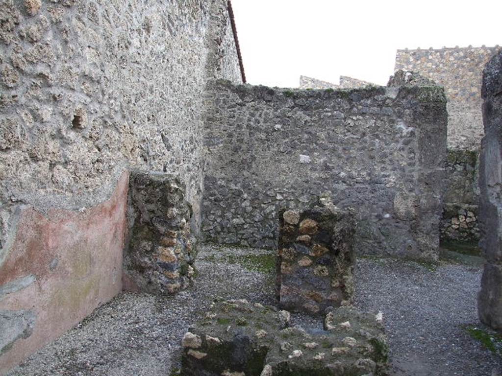 I.10.2 Pompeii. December 2006. East wall of caupona, with doorway in south-east corner to a rear room, centre, (numbered 8 on plan). 
On the right of the photo is the area numbered 7 on the plan.
