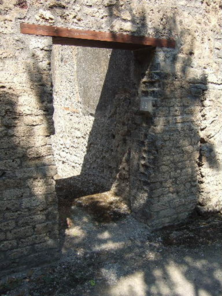 I.10.12 Pompeii. September 2005. Narrow entrance doorway.
According to NdS 
With jambs and sockets of tuff, and with a wooden threshold, access was gained to a spacious room.
This had a cocciopesto floor, walls covered with rough plaster, and a flat ceiling; the door opened to the left of the wall, to increase the lighting of the room, and a rather wide rectangular window was carved into the same south wall.
In the centre of the east wall, was a large breach from the corresponding rustic room of the Casa del Menandro and on the same wall a small doorway of communication, now closed, with the latrine of the same room.
In the west wall, the block of limestone that marked the beginning of the staircase to the upper floor was resting on the ground. 
See Notizie degli Scavi, 1934, (p.340)
