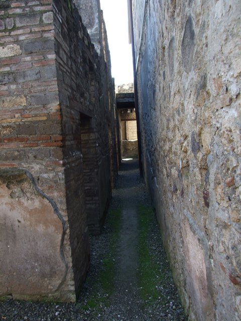 I.10.15 Pompeii.  March 2009.  Room on north side of entrance.  Corridor looking south past rooms to I.10.4.

