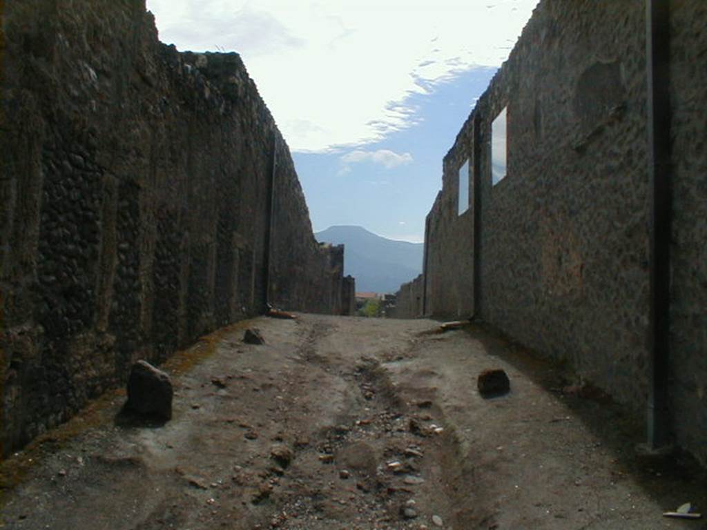 I.12 Pompeii, on left. September 2005.   Vicolo della Nave Europa, roadway, looking south.       Side wall of I.11.7/6, on right.