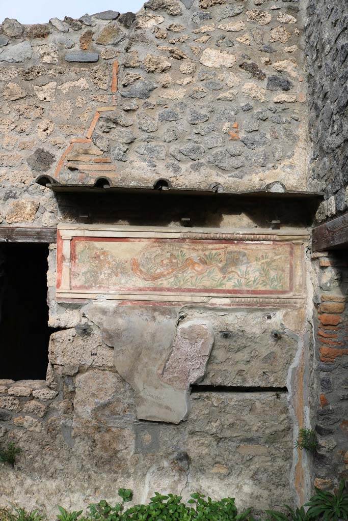 I.11.11 Pompeii. December 2018. 
Looking towards painted lararium on east end of north wall of bar-room. Photo courtesy of Aude Durand.
