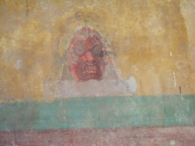 I.11.14 Pompeii. September 2005. Detail of wall painting of mask from east wall of oecus.
