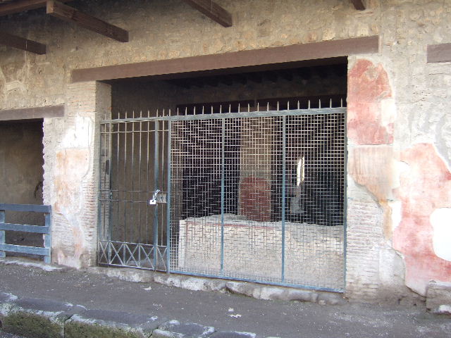 I.12.3 Pompeii. Painting by Spinazzola of entrance façade showing graffiti and painting of Minerva to right of doorway.