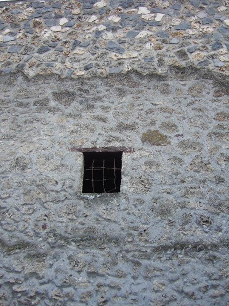 I.13.5 Pompeii. December 2005. Outside view of window with metal grate in side wall on Via di Nocera. 