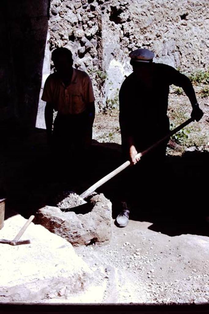 I.13.16 Pompeii. 1972. Digging lapilli from cistern head which was used as the table. 
Photo by Stanley A. Jashemski. 
Source: The Wilhelmina and Stanley A. Jashemski archive in the University of Maryland Library, Special Collections (See collection page) and made available under the Creative Commons Attribution-Non Commercial License v.4. See Licence and use details. J72f0383
