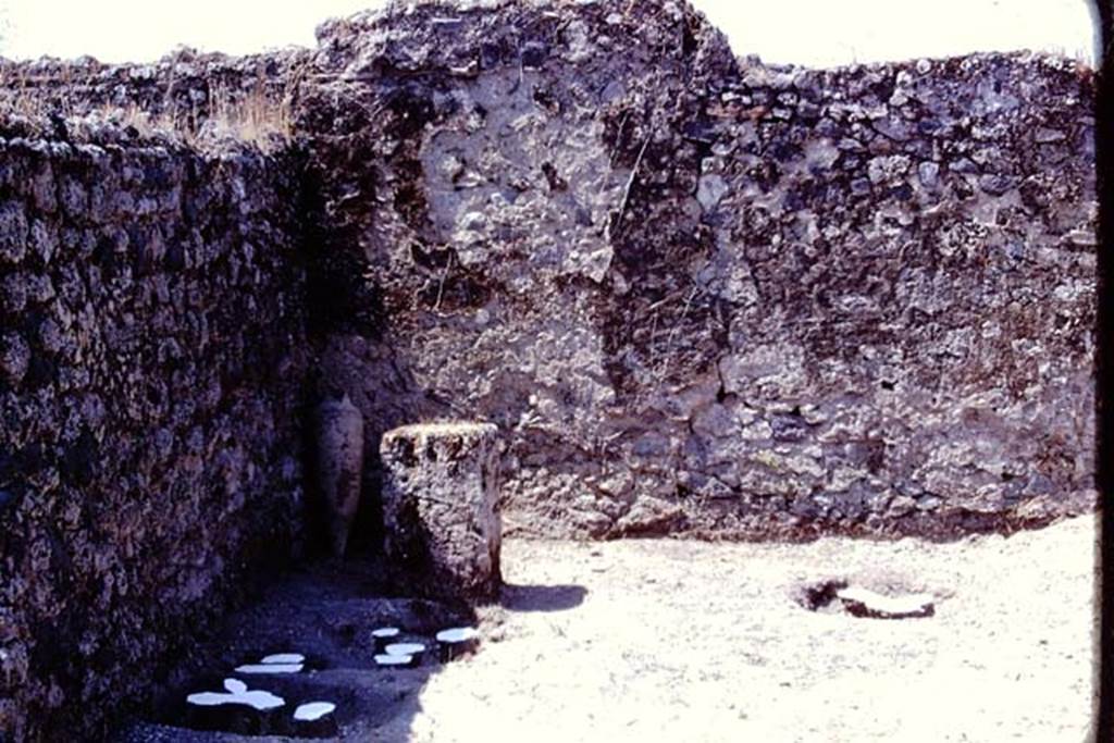 I.14.2 or I.20.5 Pompeii. 1974. Painted discs identifying root cavities near south-west corner, and masonry altar made from a large limestone block. In the corner, at the rear of the altar, the amphora is leaning against the wall. Photo by Stanley A. Jashemski.   
Source: The Wilhelmina and Stanley A. Jashemski archive in the University of Maryland Library, Special Collections (See collection page) and made available under the Creative Commons Attribution-Non Commercial License v.4. See Licence and use details. J74f0715
According to Wilhelmina, The large limestone block erected at the rear of the garden probably served as a rustic altar. There was great excitement when we found a few coins nearby, then a buried amphora with its mouth carefully closed with a stone.
See Jashemski, W.F., 2014. Discovering the Gardens of Pompeii: Memoirs of a Garden Archaeologist, (p.193)
