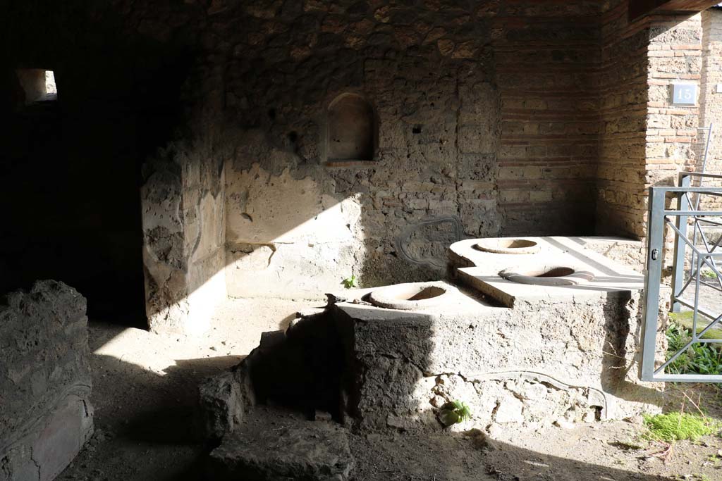 I.14.15 Pompeii. January 2019. Detail of bar/podium with remains of hearth at north end, and east wall with niche. 
Photo courtesy of Johannes Eber.
