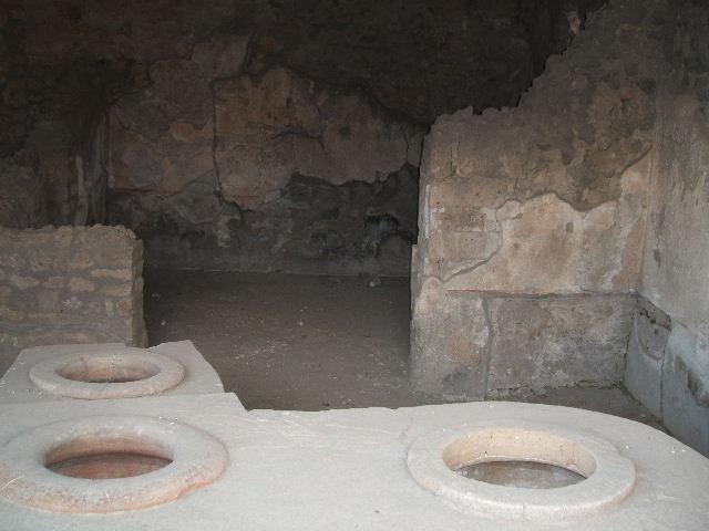 I.14.15 Pompeii. December 2004. Looking across top of counter to rear room.