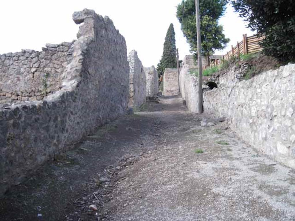 I.2.22 Pompeii. September 2010. Looking north along Vicolo del Citarista, note arch by pole on right, I.19. Photo courtesy of Drew Baker.
