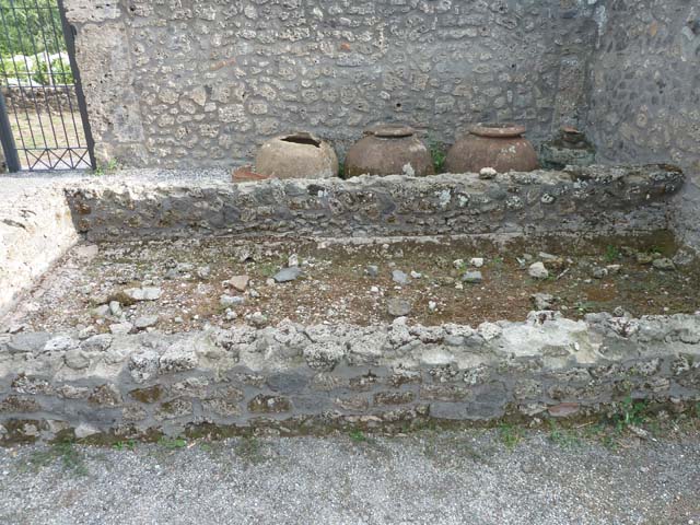 I.21.2 Pompeii. September 2015. Looking towards west wall and dolia, puteal, and remains of plaster on basin/vat.