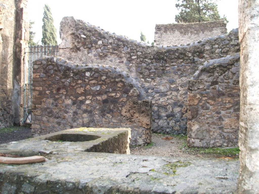 II.2.1 Pompeii. December 2004. Looking across counter to south wall and rear room. According to Boyce, on the south wall was an arched niche coated with red stucco, the same as covered the walls of the room.
The niche was outlined in yellow. See Boyce G. K., 1937. Corpus of the Lararia of Pompeii. Rome: MAAR 14. (p.30, no. 62, location given as II.v,1)  
