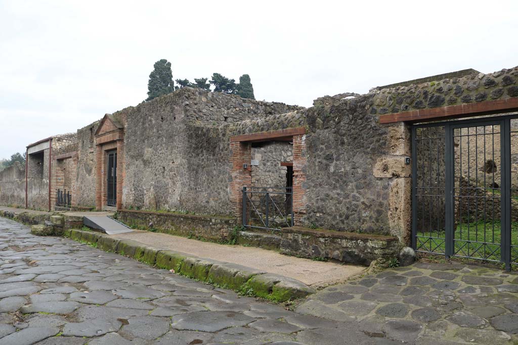 II.4.4 Pompeii, on right. December 2018. 
Looking east on Via dell’Abbondanza, with doorways II.4.4 through to II.4.7, on left. Photo courtesy of Aude Durand.
