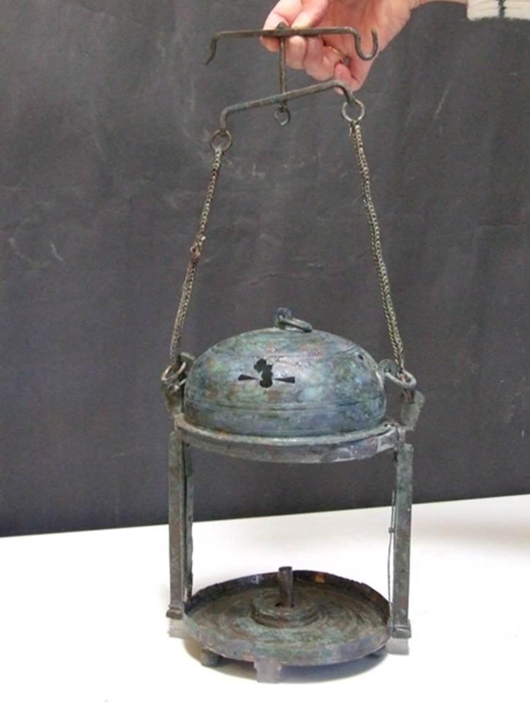 II.4.8 Pompeii. Found in 1934. Small room or stall to south of entrance. Bronze lantern. SAP inventory number 5798. The inventory card says it was found in the first room west side, vicolo crossing Via Abbondanza. “Primo vano lato O. vicolo trasversale V. Abbondanza”. According to Parslow, “In a small room near this entrance [II.4.8] the excavators came across two large bronze lanterns which originally may have been suspended by their chains from the ceiling joists, since they were found near the level of the roof”. He also identifies these with SAP inventory numbers 5798 and 5816. See Parslow, C., 1988. Rivista di studi pompeiani II. Roma: L’Erma di Bretschneider. (pp. 37).