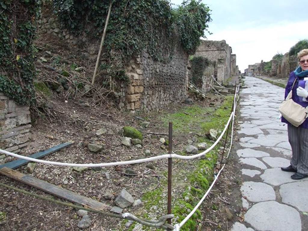 II.5.2 and II.5.1 Pompeii. December 2006. 
Looking west along footpath from II.5.2, towards site of 4 columns in footpath that probably supported a balcony overhanging Via dell’ Abbondanza. 
