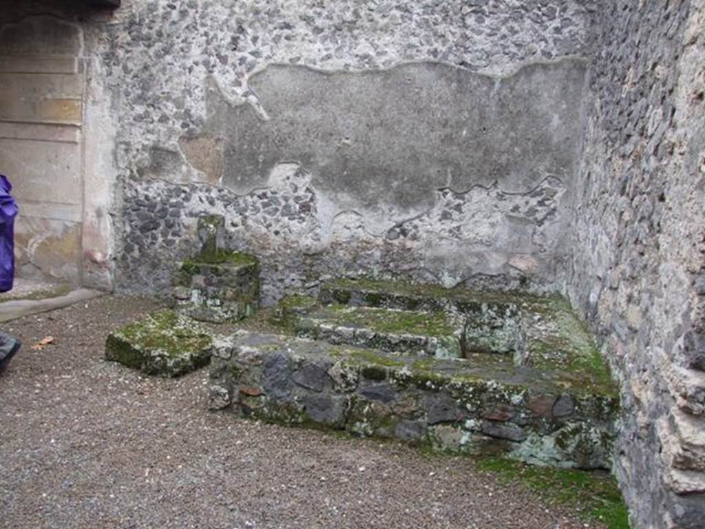 II.8.5 Officina di Sabbatino.  December 2007.  Three sided stone bench and table in south west corner of atrium area.