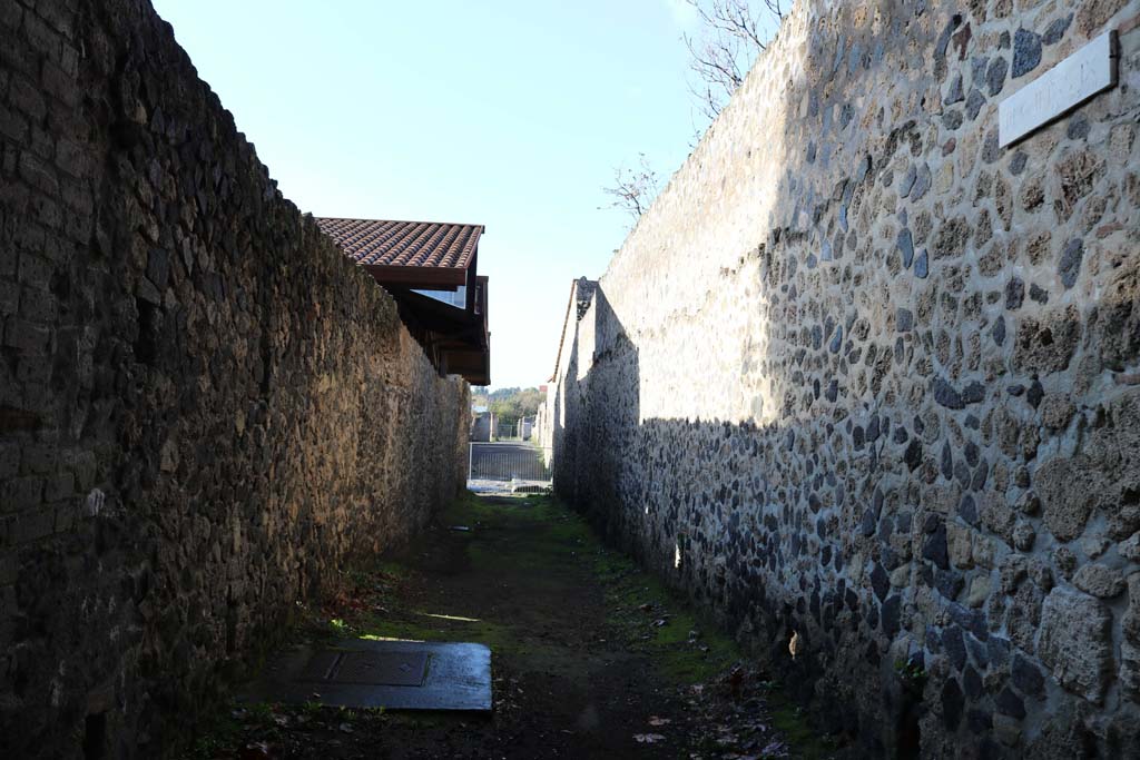 II.9.1, Pompeii, exterior south wall, Pompeii, on right. December 2018. 
Looking west on Via della Palestra. On the left is the exterior north wall of II.8.6. Photo courtesy of Aude Durand.
