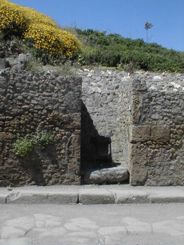 III.3.3 Pompeii. May 2005. Entrance doorway, partly excavated.
According to Garcia y Garcia, a bomb dropped during the bombardment of 19th September 1943 destroyed the faade of III.3.4.
This led to the disintegration of the pilasters and doorposts of three entrances, (III.3.3, III.3.4 and III.3.5).
Also ruined were the dividing walls and the perimeter wall onto Via dellAbbondanza for 26 x 5 metres.
In III.3.5 the internal walls were also destroyed.
See Garcia y Garcia, L., 2006. Danni di guerra a Pompei. Rome: LErma di Bretschneider. (p.53)
