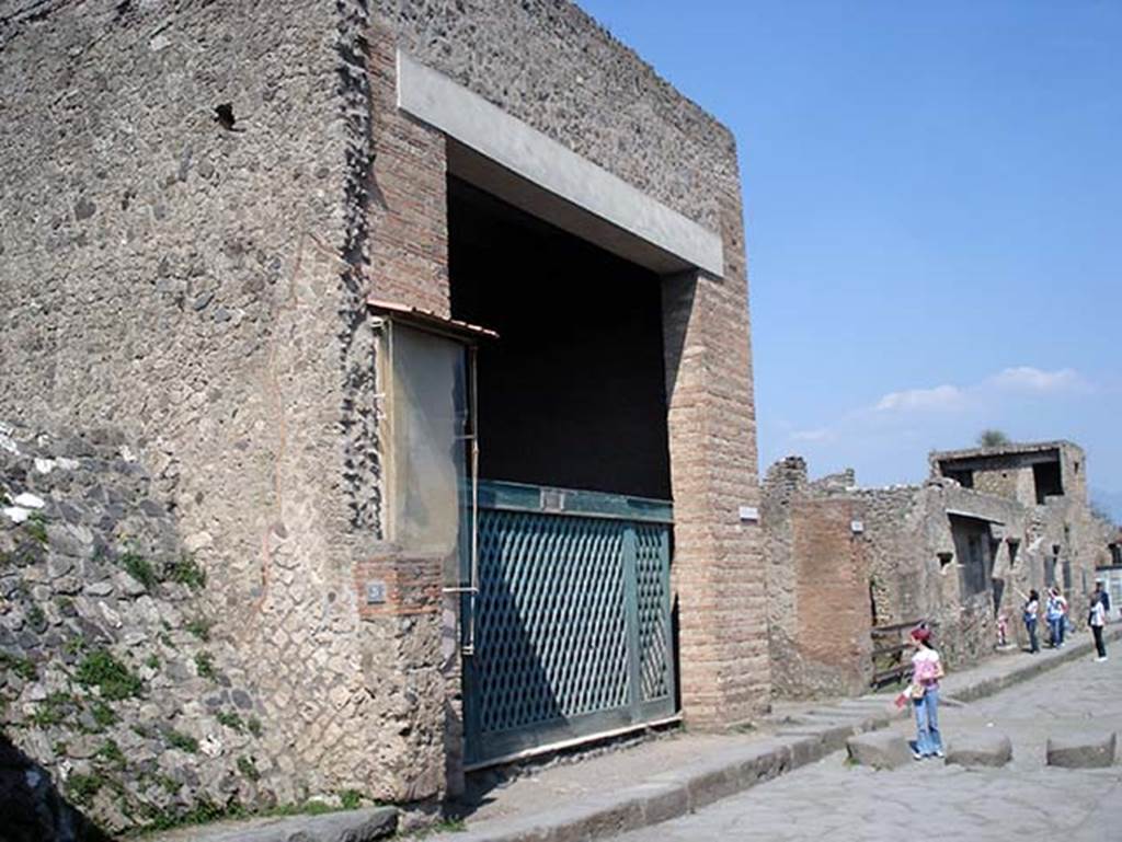 III.3.6 Pompeii. May 2005. 
Entrance, with reproduction of the original type of doorway gate.
The entrance doorway was almost as wide as the room behind it.  
It was thought this, full of military emblems, weapons, cupboards, etc, was occupied by a military association.
