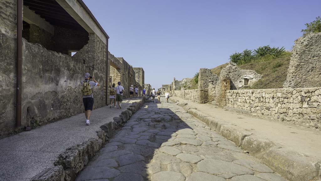 III.7.5 Pompeii, wider threshold in newly constructed wall, right of centre of photo. August 2021. 
Looking west along newly constructed wall along III.7 on north side of Via dell’Abbondanza. II.4.7 is on the left. 
Photo courtesy of Robert Hanson.

