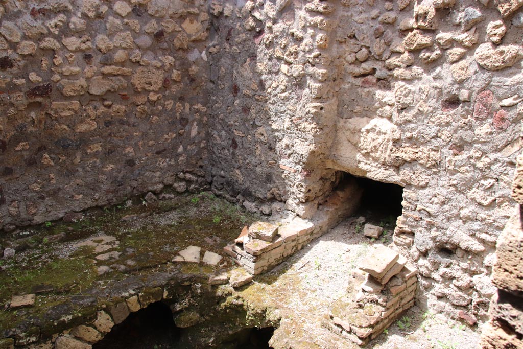 V.1.7 Pompeii. May 2024. Room “l” (L), looking north-west towards kitchen bench, hearth and chimney. Photo courtesy of Klaus Heese.