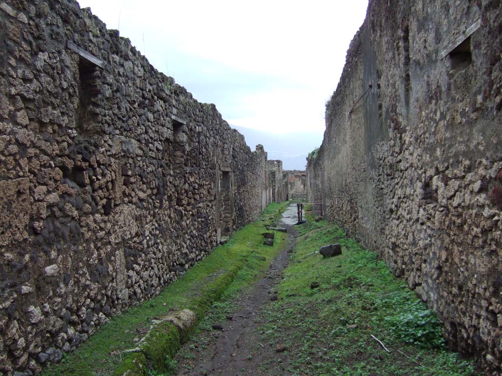 V.2 Pompeii, on left. December 2005.     Vicolo di Cecilio Giocondo, looking south.             Side wall of V.1.11, on right.