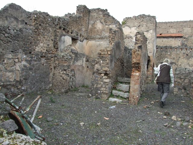 V.4.1 Pompeii. December 2007. Room “L” on west side of stone steps to upper floor.
In the north wall were the holes for supporting the shelves, on which the baked bread was placed. 
