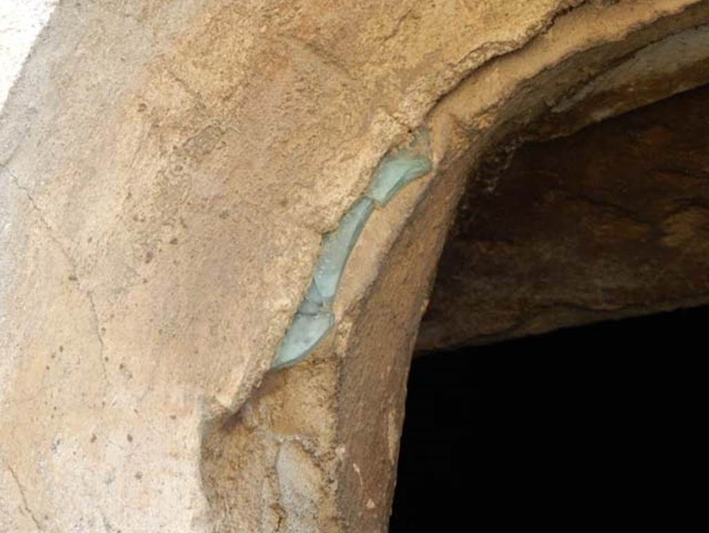 V.4.a Pompeii. May 2015. 
Room ‘m’, detail of remains of glass in south exterior side of small circular window to cubiculum. Photo courtesy of Buzz Ferebee.
