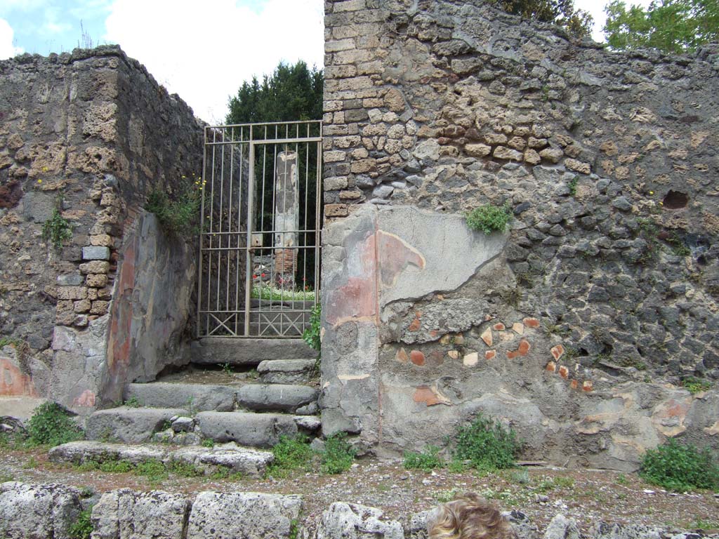 V.5.3 Pompeii. May 2006. Remains of painted plaster on wall to right of entrance.