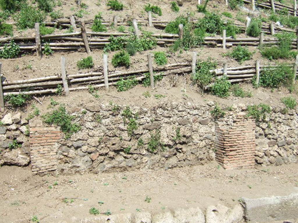 V.6.10 Pompeii, (in centre). May 2006. Unexcavated facade and entrance.
V.6.11, entrance doorway (on left), V.6.9 on right.
