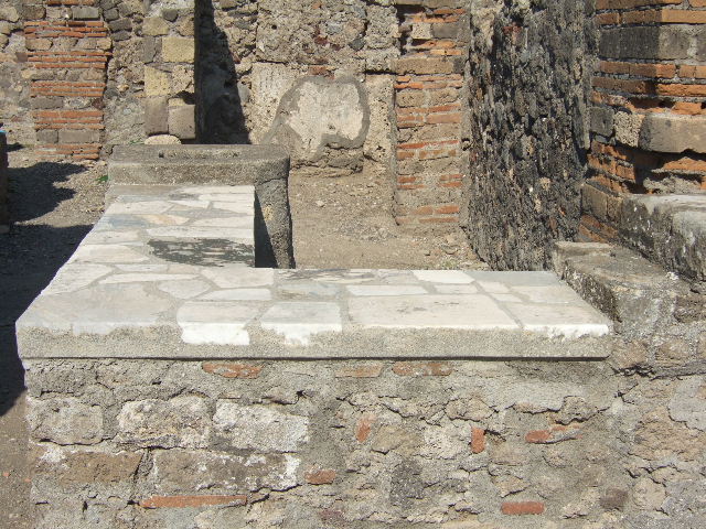 VI.1.2 Pompeii.  September 2005.  Counter with marble top, hearth and display shelves.
