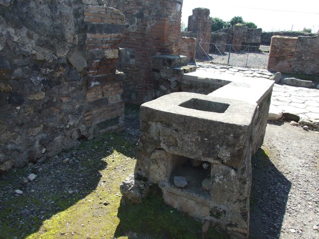 VI.1.2 Pompeii.  March 2009.  Looking west across hearth and counter to Via Consolare.