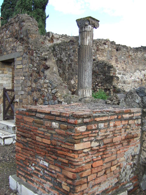 VI.1.13 Pompeii. May 2006. East wall. Remains of marble clad pedestal. Statue base?