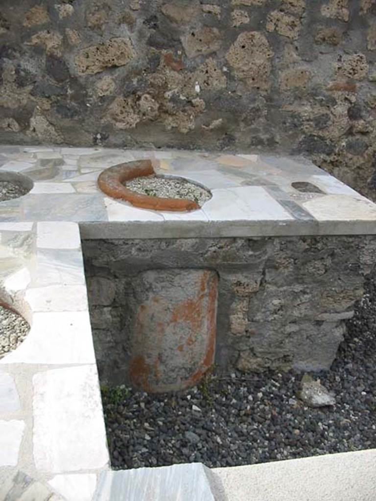 VI.2.1 Pompeii. May 2003. Base of terracotta urn, embedded into counter. Photo courtesy of Nicolas Monteix.