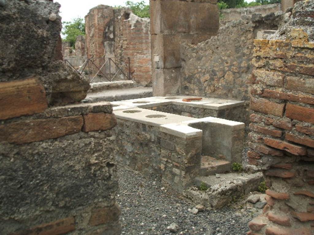 VI.2.1 Pompeii.  May 2005.  Looking from rear. Marble counter with six urns and a hearth.
