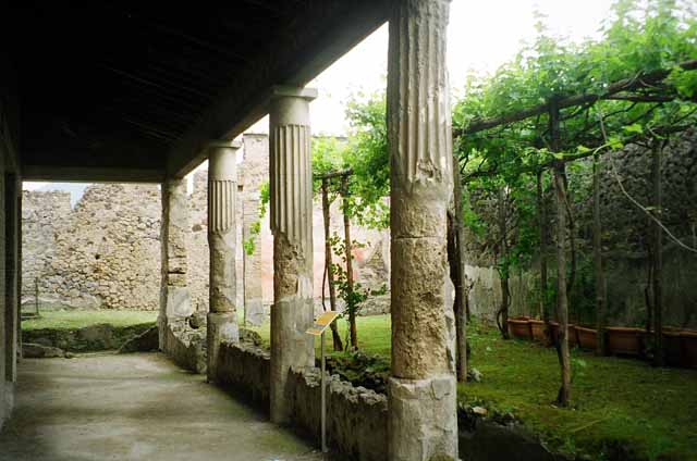 VI.2.4 Pompeii. September 2004. Looking south-east across portico of small garden. This was originally a three sided peristyle. It was destroyed by a huge bomb in September 1943. It was reconstructed in 1970-71 based on an 1824 plan by Mazois. It should be noted that  apart from the west side, the house was entirely destroyed by the bombing during the night of 14/15th September 1943.  According to Laidlaw, the roof, the south apartment, and the portico behind the main house block are almost completely modern reconstructions made in 1970-71. See Garcia y Garcia, L., 2006. Danni di guerra a Pompei. Rome: L’Erma di Bretschneider. (p. 66-74)


