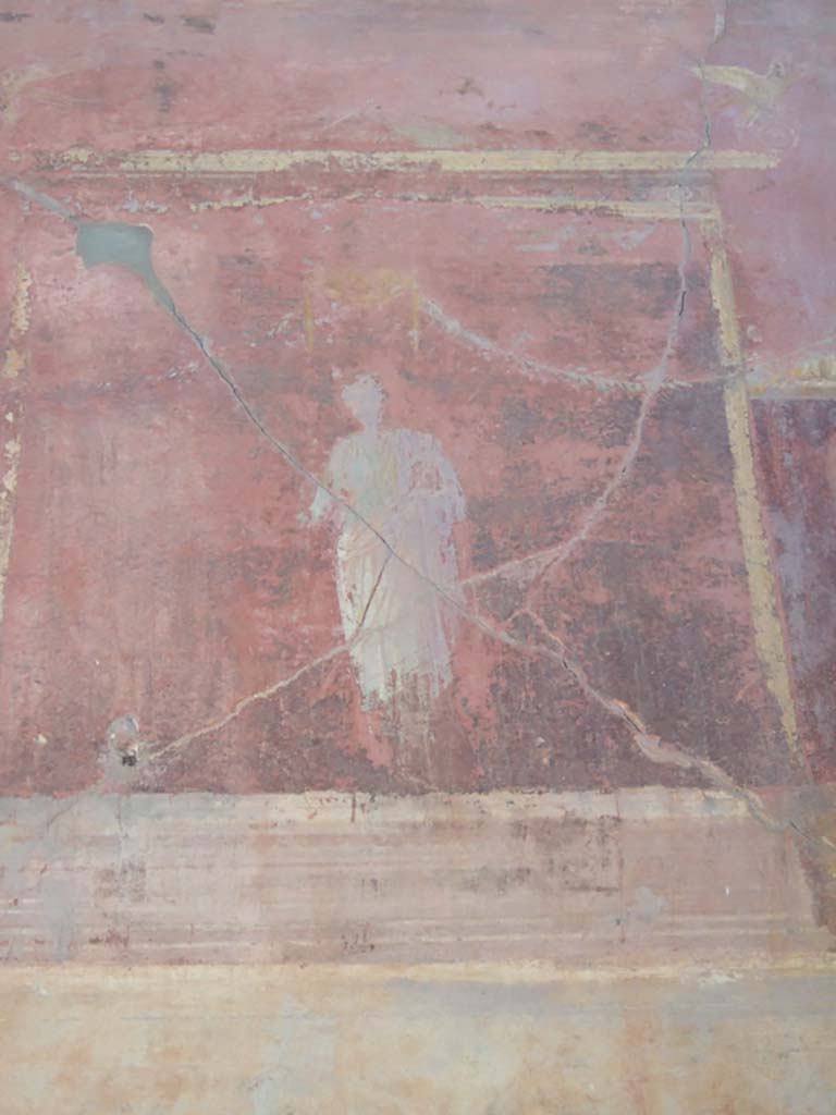 VI.2.14 Pompeii. September 2005. 
Triclinium, detail from painted upper west wall, central figure above blue panel.  
