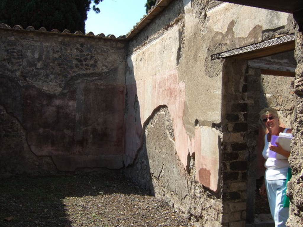 VI.2.22 Pompeii. September 2005. Looking west into triclinium. On the right can be seen the doorway to the west portico, and a doorway into a cubiculum on south side of rear doorway at VI.2.15.

