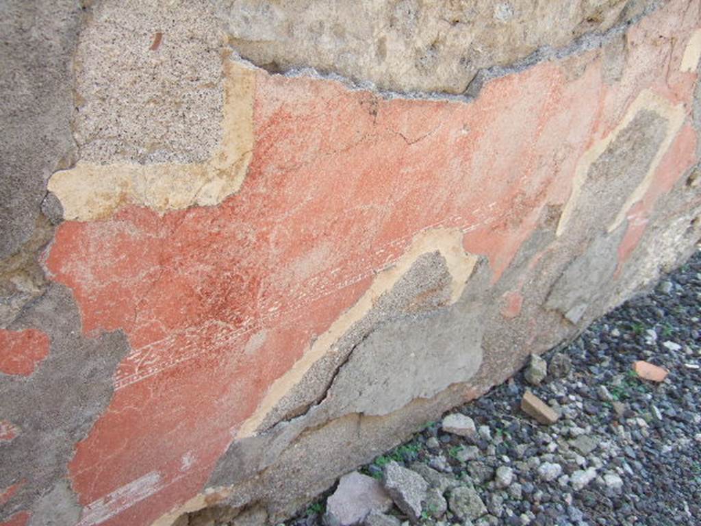 VI.2.25 Pompeii. September 2005. Remains of painted plaster on south wall of entrance corridor.