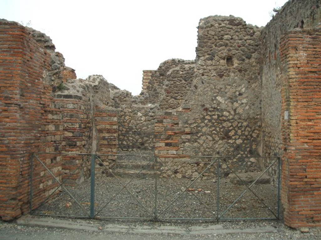 VI.3.4 Pompeii. May 2005. Entrance doorway, looking east. In the north wall (on left) is a doorway into a room with window. In the east wall there are two steps to a rear room. In the south-east corner there is a base for stairs to an upper floor.
