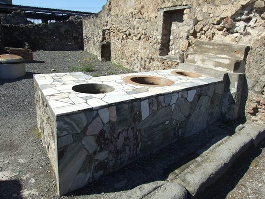 VI.4.8 Pompeii. March 2009. 2 sided marble sales counter, with 3 urns and small display shelving. On the north wall can be seen a rectangular niche.