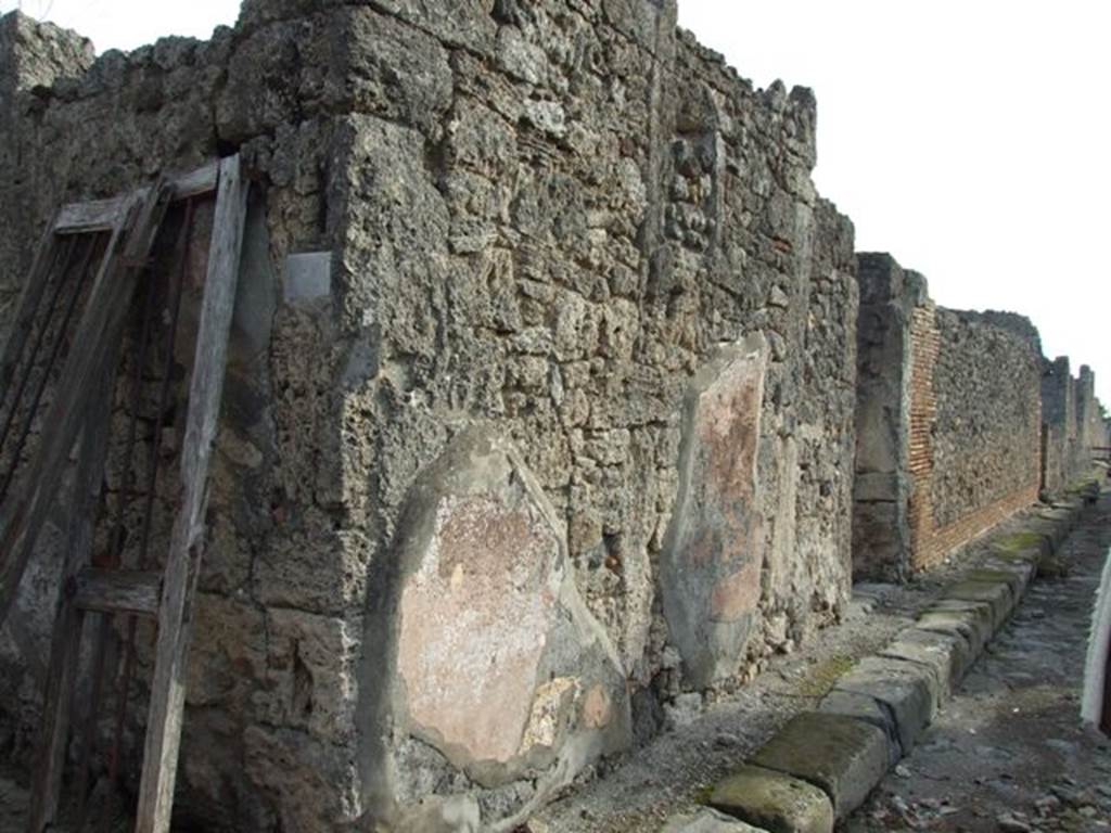VI.5.9 Pompeii. December 2007. Wall in Vicolo di Modesto between VI.5.9 and VI.5.10, looking south. According to Fiorelli, the exterior walls of the house were plastered red.
