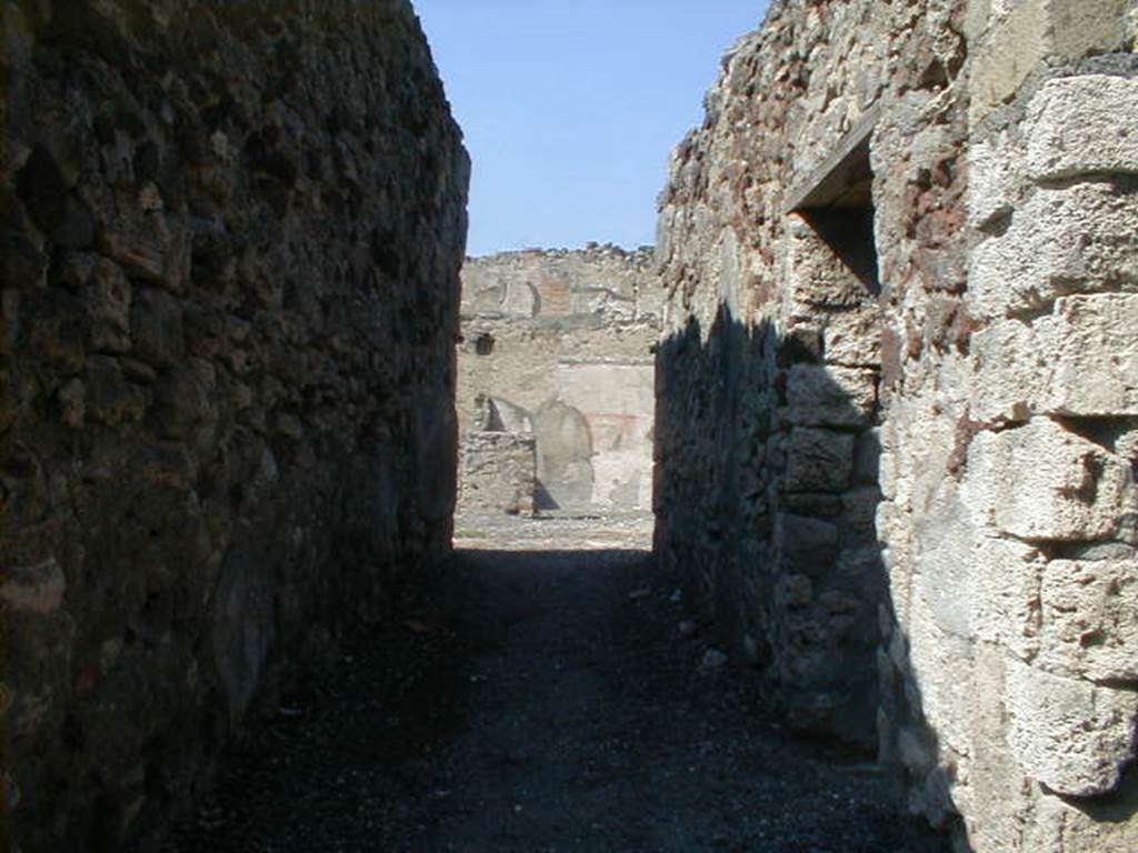 VI.5.13 Pompeii. September 2004. Looking north along entrance corridor leading to atrium. On the right is the doorway into the kitchen and latrine.
According to Dyer, this would have been a middle-class house, having an atrium but no peristyle. The atrium was “displuviatum”: that is, the roof instead of sloping down to the four-sides of the square opening in the middle of it, and thus throwing the rainwater into the impluvium (or the basin below), slanted away from it towards the sides of the house, and thus threw the rainwater outside instead of inside. There were rooms on each side of the prothyrum (or entrance corridor), which was very long for the size of the house. The larger room, on the left (see VI.5.12), was evidently a shop (or bar) as it had a stone counter in it. As it was connected with the interior of the house, it was no doubt kept by the same proprietor. The smaller rooms on the other side of the entrance corridor were probably used as a kitchen and a small room, possibly for the slave who acted as porter or door-keeper. On the further side of the atrium were two rooms which were handsomely decorated. Their use cannot be certainly determined, but one of them probably served as a dining-room. On the left-hand side of the atrium was a flight of stairs leading to two rooms on the upper floor. Notwithstanding its small size, this house was very beautiful and tastefully decorated with paintings, the subjects of which were taken from Greek mythology, and from Homer’s Odyssey. They have now perished, but they were perfect in 1812 when seen by Mazois, who made copies of them. One of them represented Ulysses drawing his sword upon Circe to avenge his companions transformed by the enchantress. Circe is using the supplicatory gesture so frequently described in the Greek poets, by falling on her knees and endeavouring to clasp with one hand the knee of Ulysses, while she stretches out the other to touch his beard. Her head is surrounded with a nimbus, or glory, which appears like a plate of solid gold, resembling that seen around the heads of saints in early Christian pictures.
Another painting represented Ulysses discovering Achilles at Scyros among the daughters of Lycomedes.
See Dyer, Thomas: The ruins of Pompeii, 1867, (p.75-76)



