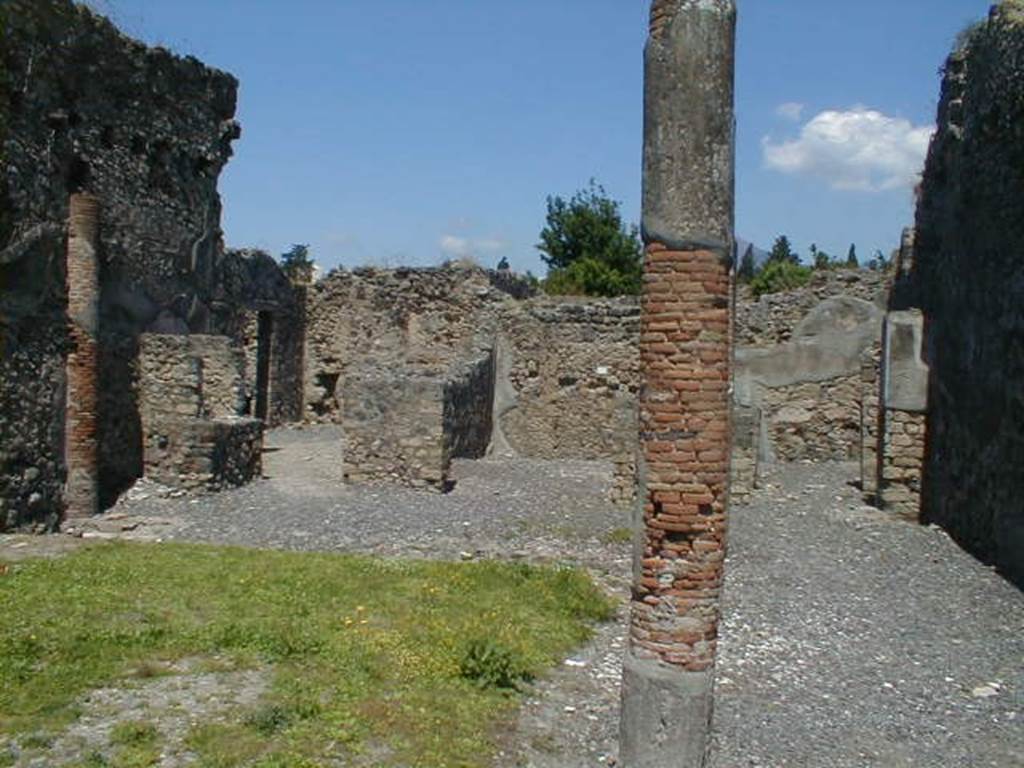 VI.5.14 Pompeii. May 2004. Looking north along east portico towards rear rooms on north side. The lararium can be seen on the left.
