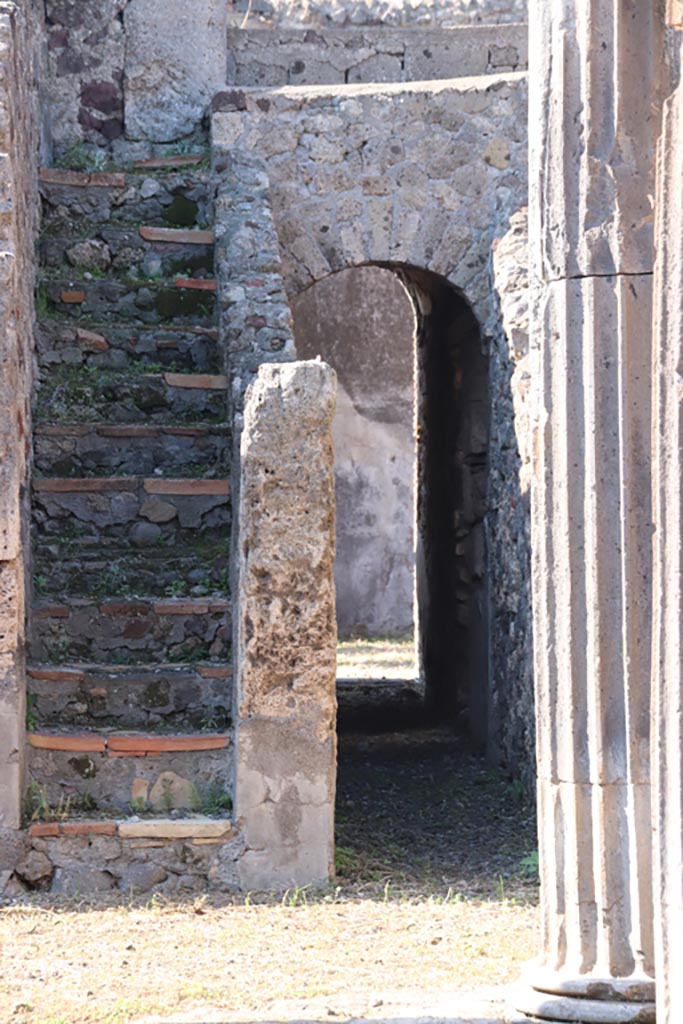 VI.7.21 Pompeii. September 2005. Staircase to upper floor, and corridor through arch to rear and linking with peristyle of VI.7.20.

