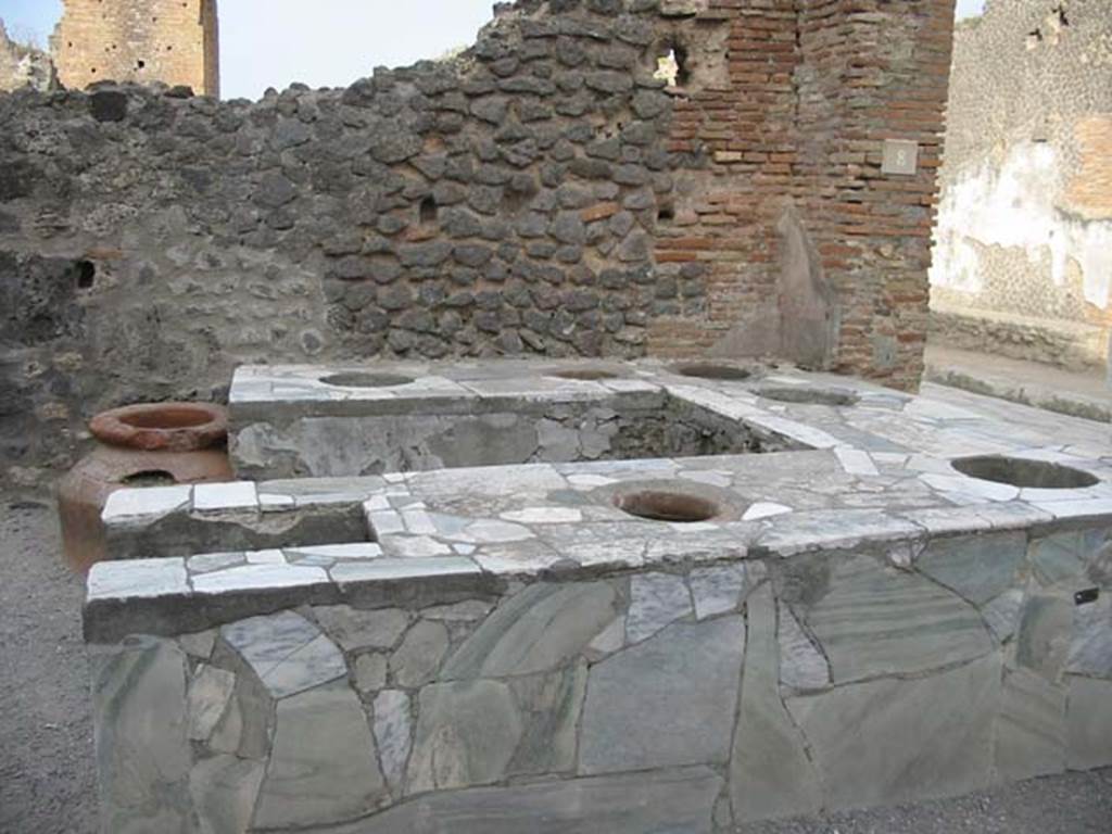 VI.8.8 Pompeii. May 2003. Looking east across counter, with hearth at rear. Photo courtesy of Nicolas Monteix.
